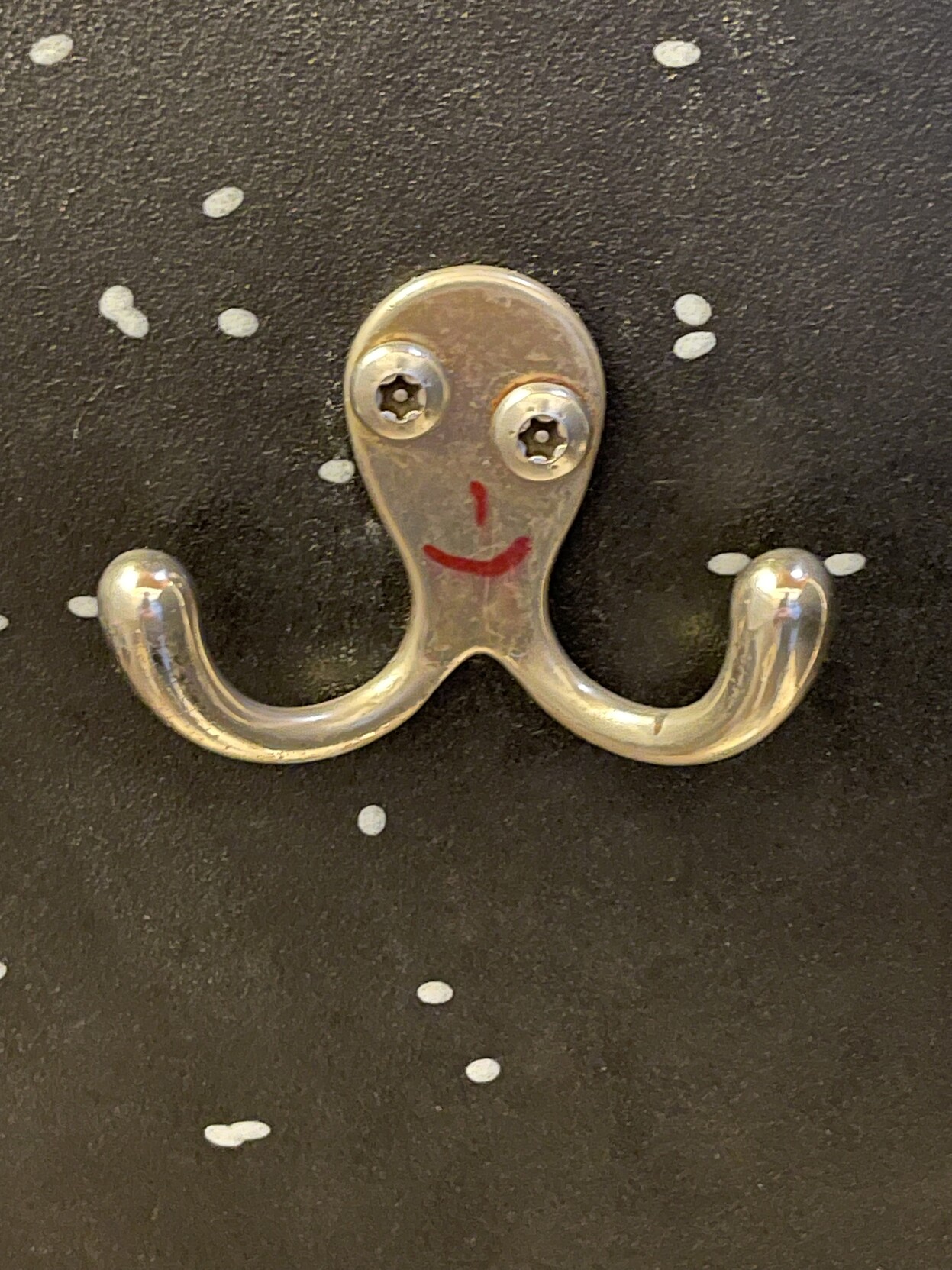 a bit of well-placed graffiti turns a kind of coat hook into a smiling octopus.