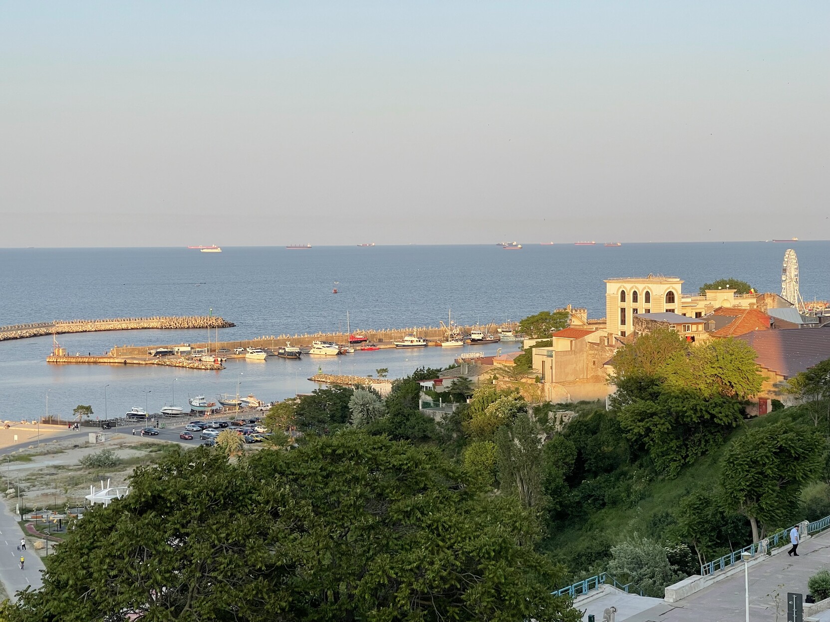 the sunset light touches Portul Tomis in Constanta, Romania. the sea is flat, waveless.